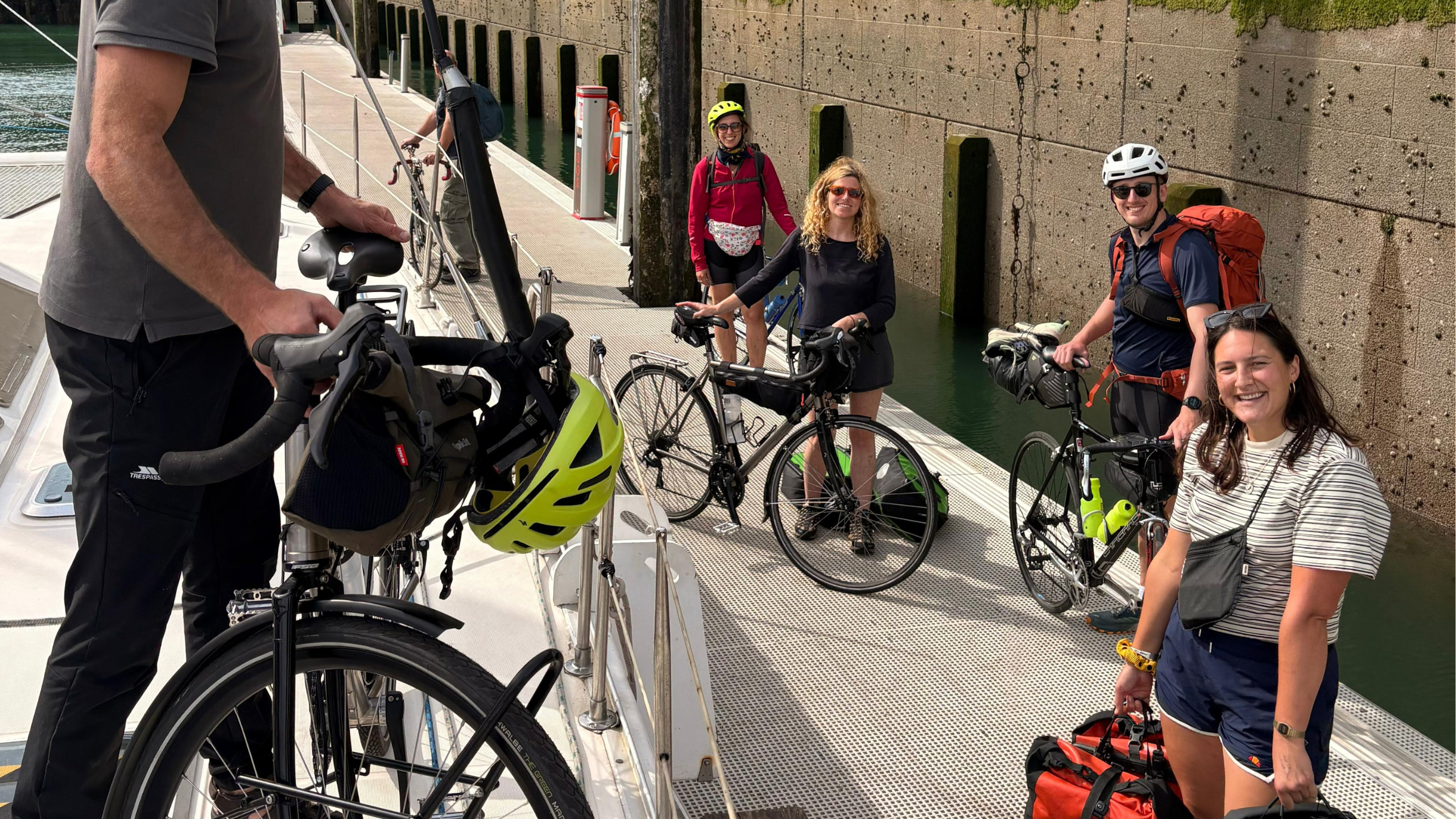Passengers loading their bikes aboard the SailLink catamaran from the pontoon at Dover marina