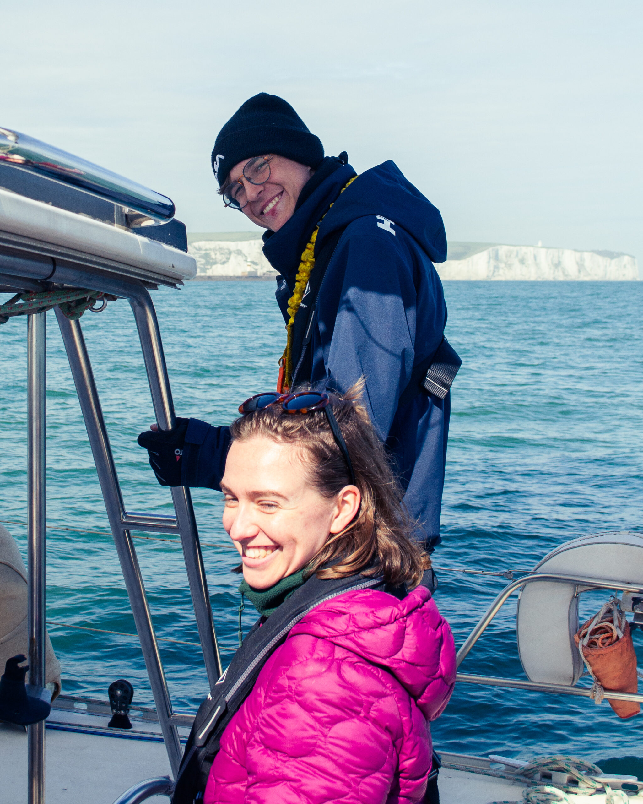 A passenger at the helm of the SailLink catamaran mid-Channel, sails up