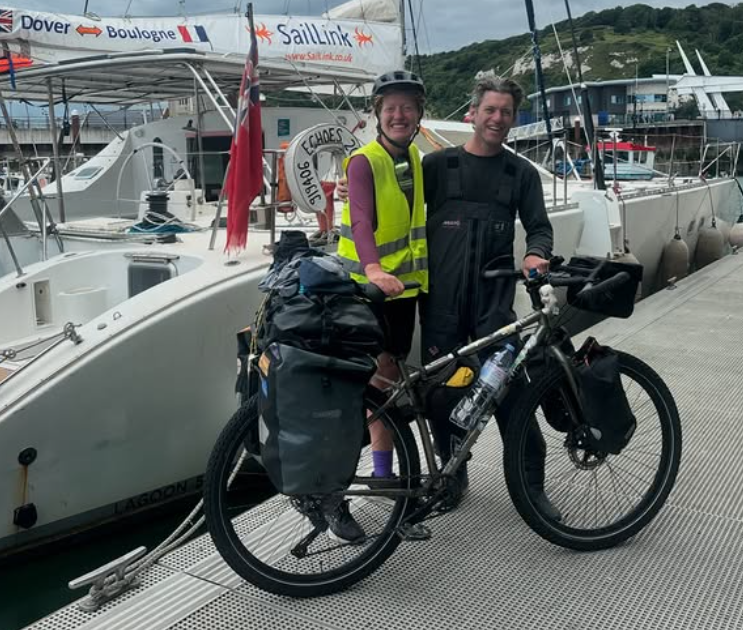 Claire Wyatt et son vélo de voyage chargé sur le ponton, à côté du catamaran SailLink, au terme de son retour à vélo depuis la Mongolie