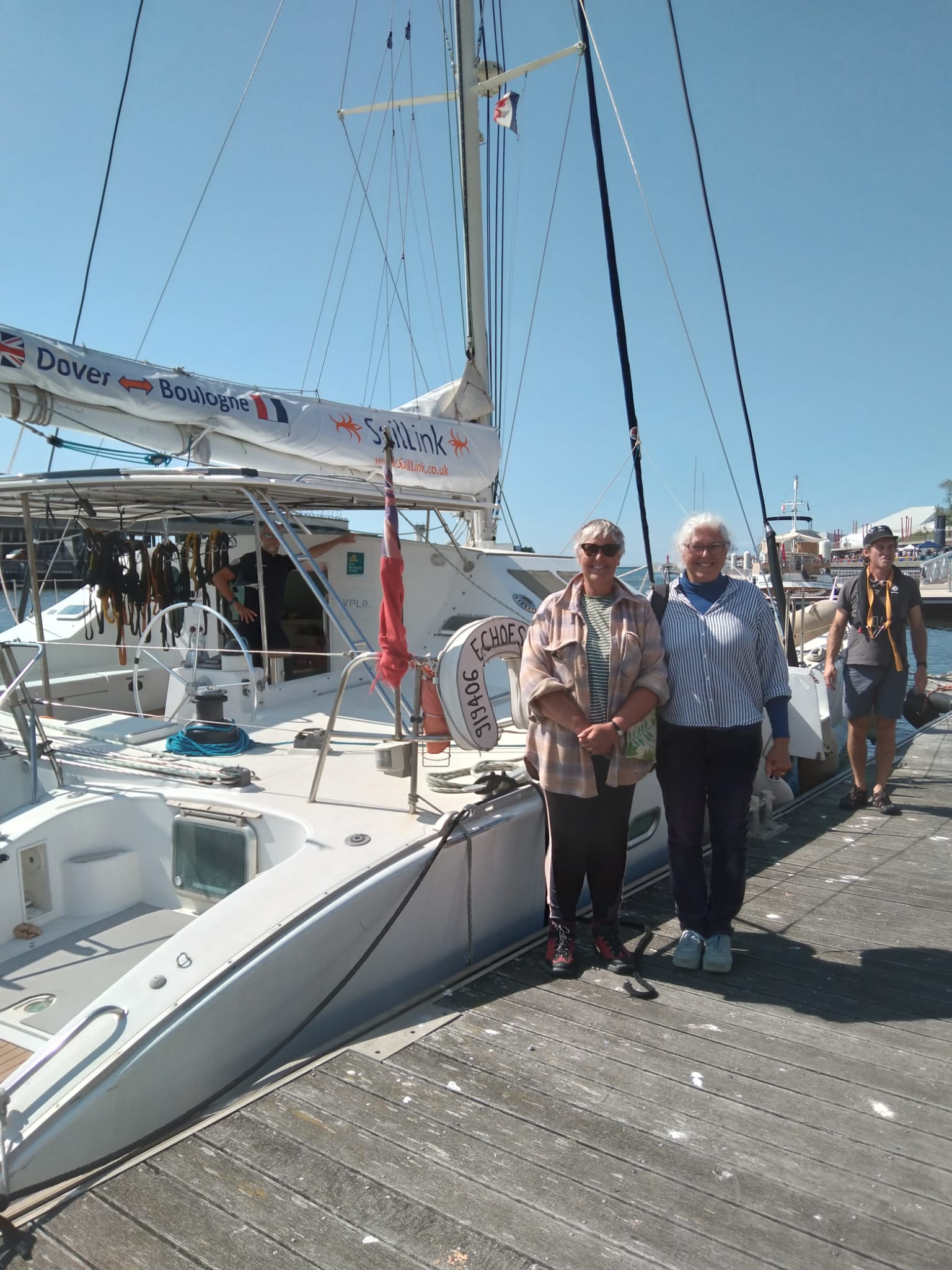 Two sisters reunited and smiling together aboard a SailLink catamaran crossing the Channel